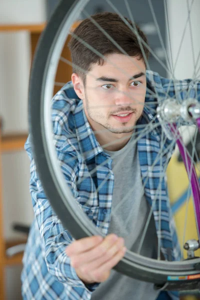 Hombre trabajando en rueda de bicicleta — Foto de Stock