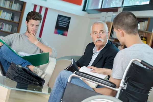 Mladý student na vozíku s učitelem — Stock fotografie