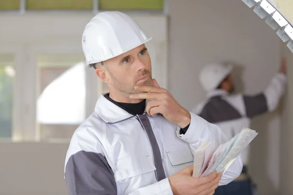 Verwirrter Bauarbeiter hält Wasserwaage in neuem Haus — Stockfoto