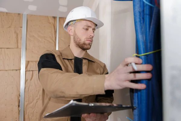 Techniker überprüfen den Zustand der Wasserleitungen in Innenräumen — Stockfoto