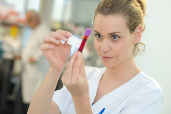 Enfermera etiquetando sangre en un tubo de vacío — Foto de Stock