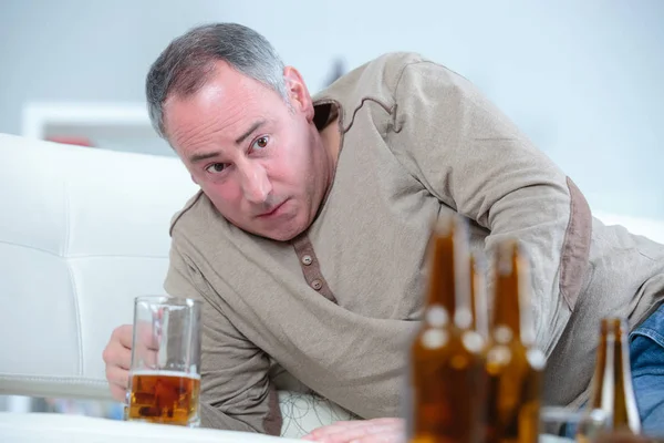 Μεθυσμένος μέση ηλικία ο άνθρωπος αναπαύεται στο σπίτι με μια μπύρα — Φωτογραφία Αρχείου