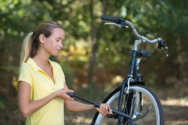 Flicka pumpar upp cykeldäck — Stockfoto