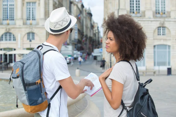 Couple of tourists using book in town — Stock Photo, Image