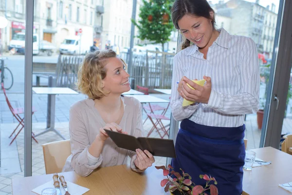 Usmívající se žena s menu v restauraci — Stock fotografie