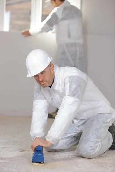 Builder polishing wood floor — Stock Photo, Image