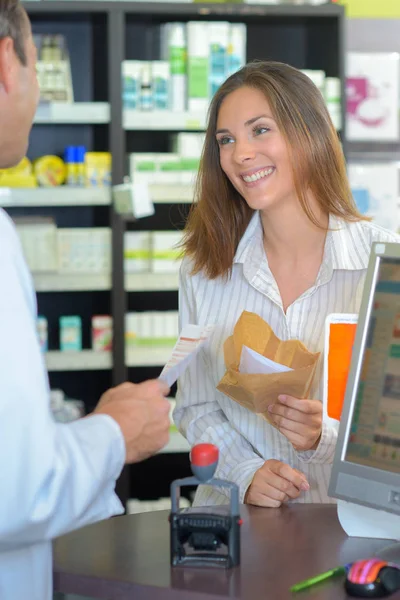 药剂师和快乐的客户，与药物和处方在药店 — 图库照片