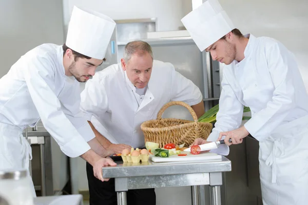 Nauczyciel pomaga uczniom szkolenia do pracy w gastronomii — Zdjęcie stockowe