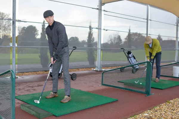 Vater und Sohn spielen Golf in der Halle — Stockfoto