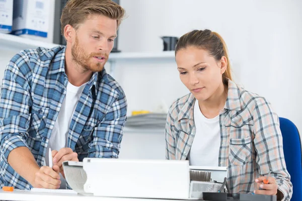 Man fixing computer with woman watching — Stockfoto