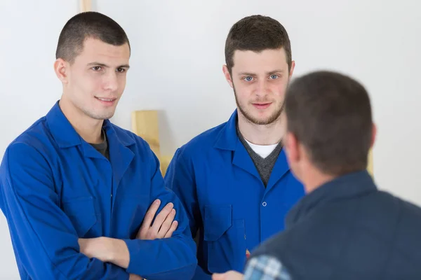 Jovens trabalhadores manuais conversando — Fotografia de Stock