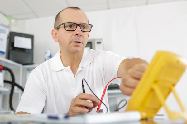 取り組んでいる電気メーターの電気技師 — ストック写真