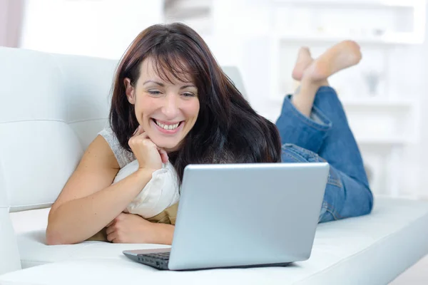Женщина смотрит фильм на ноутбуке — стоковое фото