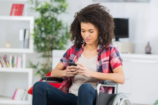 Handikappad kvinna i rullstol på mobiltelefon — Stockfoto