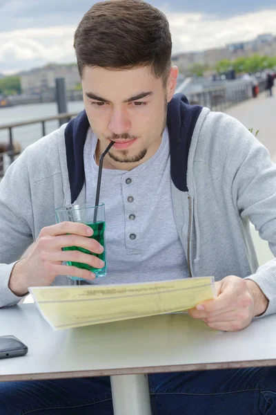 Uomo bere e leggere libro in mensa — Foto Stock