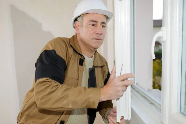 Homem que instala persianas em uma casa — Fotografia de Stock