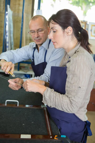 Senior shoemaker training apprentice to work with leather — Stock Photo, Image