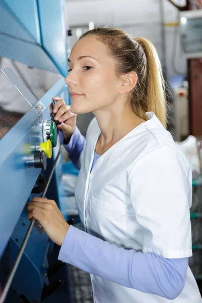 Leende unga kemist använder maskinen i laboratoriet — Stockfoto