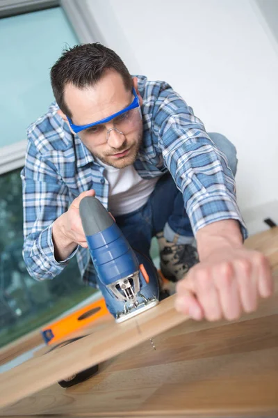 Craftsman cutting wooden plank — Stock Photo, Image