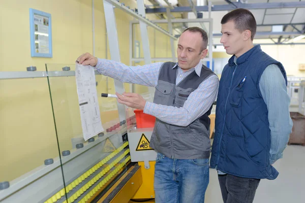 Arbeider en zakenlieden met documenten in magazijn — Stockfoto