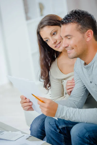 Lyckligt par läsa ett brev på en soffa hemma — Stockfoto