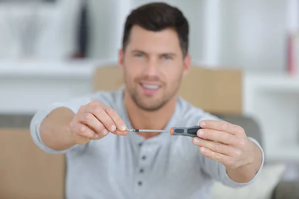 Homem positivo mostrando uma chave de fenda — Fotografia de Stock