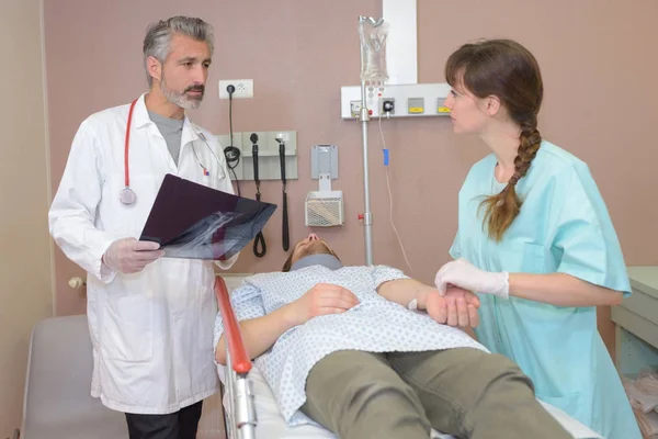 Läkare söker efter hans patient med en sjuksköterska — Stockfoto