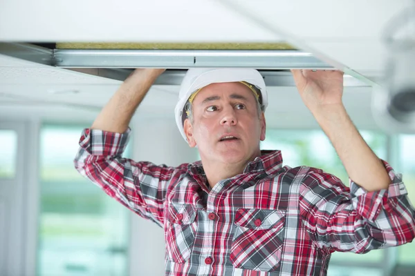 Hombre haciendo una instalación de aire acondicionado y calefacción por conducto —  Fotos de Stock