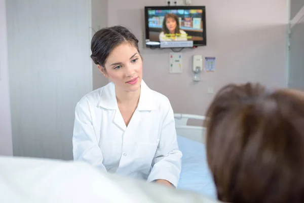 Медсестра разговаривает с пациентом в больнице — стоковое фото