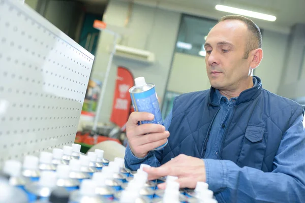 Worker tidying up spray bottles at wareshop — Stock Photo, Image