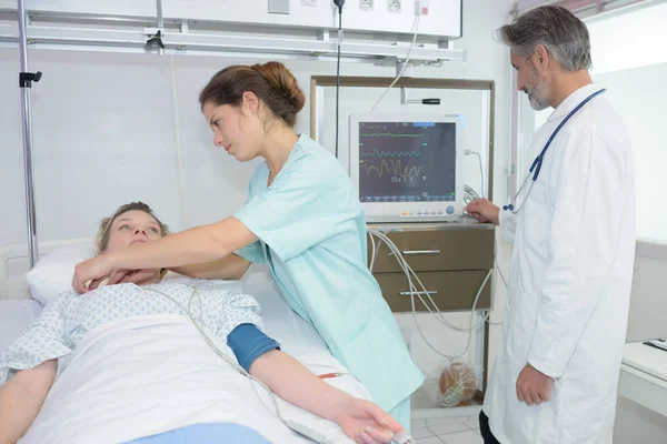 Arzt und Krankenschwester interagieren im Krankenhauszimmer miteinander — Stockfoto