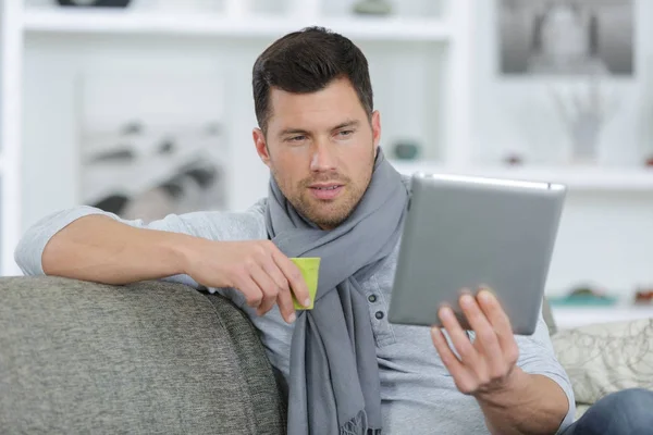 Erwachsener Mann auf Sofa mit Tablet — Stockfoto