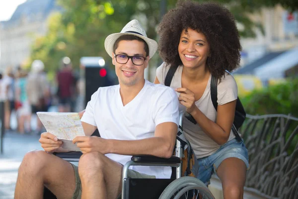 Мужчина в инвалидной коляске и девушка в праздники — стоковое фото