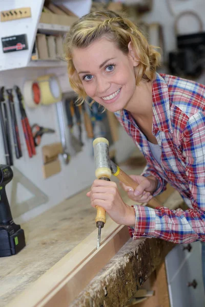 Vrouwelijke timmerman met beitel in handen — Stockfoto