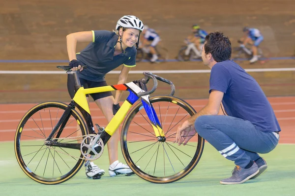 Ciclista e treinadora feminina em pista coberta — Fotografia de Stock