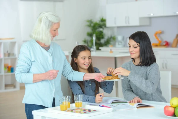 Chica con madre y abuela comer creps en casa — Foto de Stock