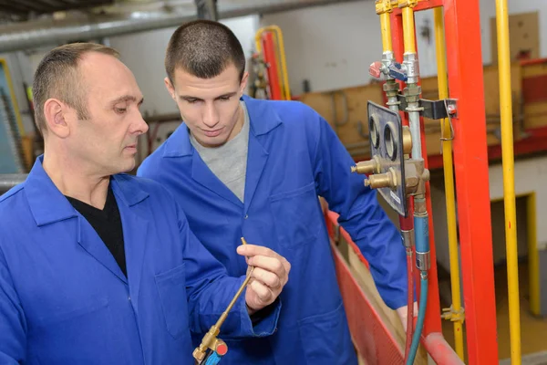 Loodgieter en leerling passend centrale verwarming — Stockfoto