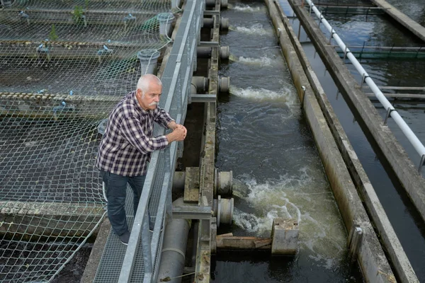 Ficherman olhando para a barragem de água — Fotografia de Stock