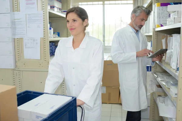 Farmacêutico sorridente e técnico de farmácia na farmácia — Fotografia de Stock