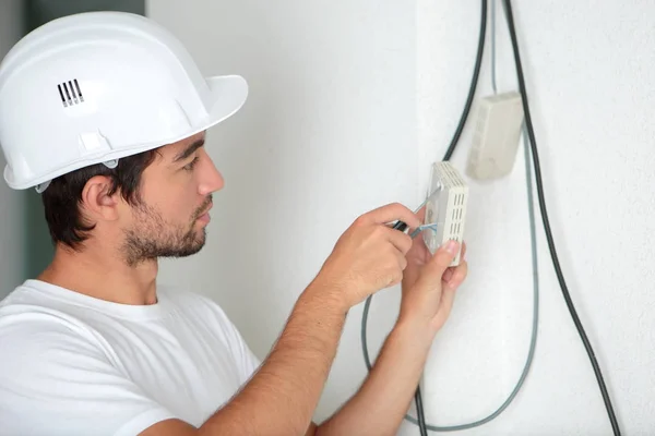 Eletricista trabalhador homem instalar um termostato — Fotografia de Stock