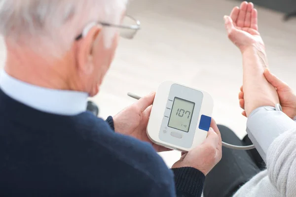 Vecchio mand mesuring mogli pressione sanguigna — Foto Stock