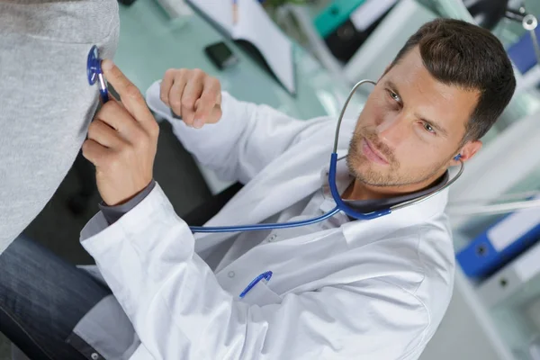 Médico segurando estetoscópio em sua mão e fazendo ausculta — Fotografia de Stock