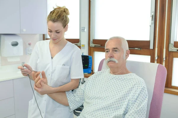Женщина врач с помощью Ланселет на мужчин палец в клинике — стоковое фото