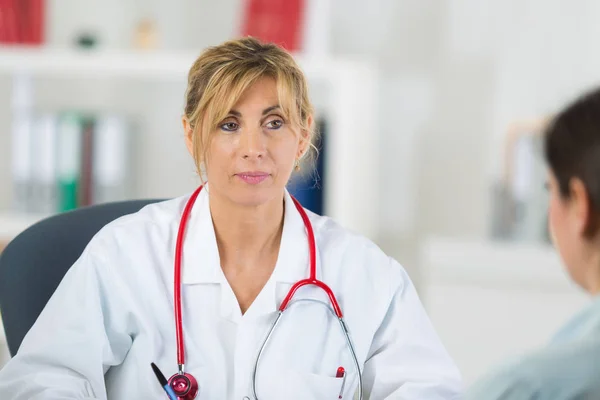 Женщина врач слушает своего пациента — стоковое фото