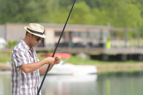 Homem perto do lago se prepara para enfrentar a pesca — Fotografia de Stock