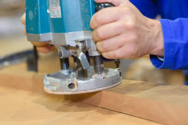 Trabalho de carpinteiro com máquina de areia em fundo de paletes de madeira — Fotografia de Stock