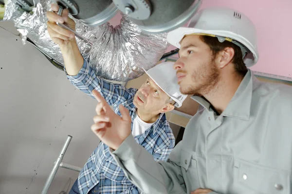 Builders working on ventilation system — Stock Photo, Image