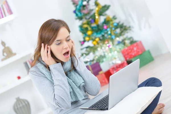 Jonge vrouw zitten in de buurt van de kerstboom met koptelefoon — Stockfoto