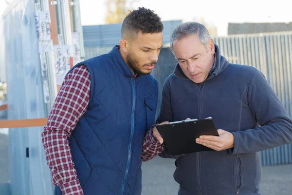 Superviseur et travailleur avec presse-papiers à l'extérieur de l'entrepôt — Photo