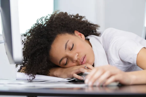 Junge Frau schläft am Arbeitsplatz auf Laptop — Stockfoto